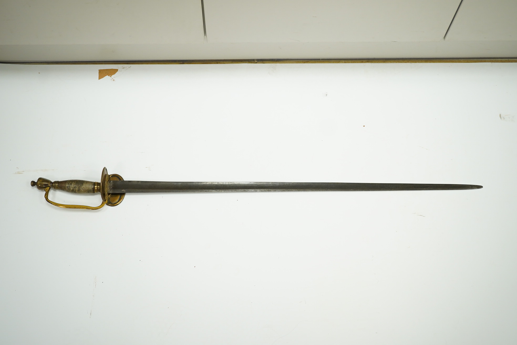 A 1796 pattern infantry officer's sword with regulation single edge blade, hilt with traces of gilding. Condition - fair, grip covering and quillon incomplete.